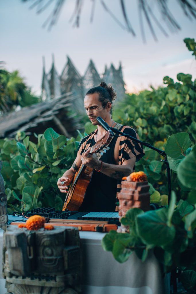 Con una guitarra en manos y una pasión desbordante por la música, J.Pool es un artista cuyo viaje lo ha llevado a fusionar ritmos de todo el mundo, encontrando en Tulum el escenario perfecto para su arte. 